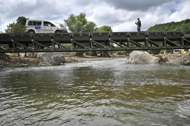 A car is guided across a temporary bridge over the River Ahr in Insul.