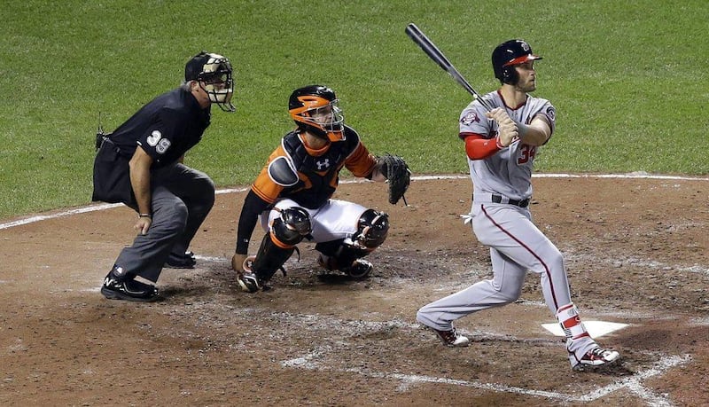 Washington Nationals' Bryce Harper, right, watches his solo home run in front of Baltimore Orioles catcher Caleb Joseph and home plate umpire Paul Nauert in the sixth inning of an interleague baseball game, Saturday, July 11, 2015, in Baltimore. (AP Photo/Patrick Semansky)