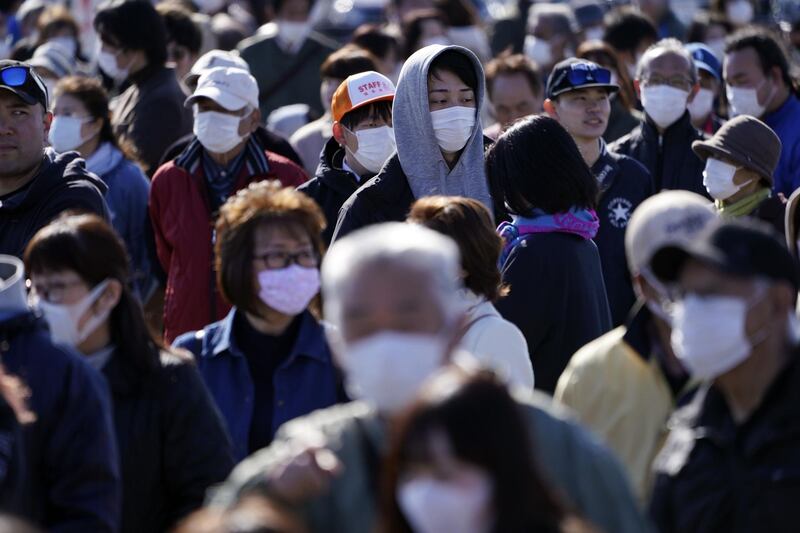 Spectators wait to see the Olympic flame display ceremony in Iwaki, Fukushima. AP