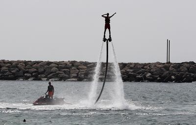 DUBAI, UNITED ARAB EMIRATES, August 25 – 2018 :- People enjoying the Jet ski and fly boarding during the hot and humid weather at the Jumeirah beach in Dubai.  ( Pawan Singh / The National )  For Standalone/Big Picture