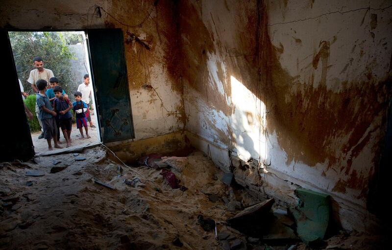Palestinians inspect the damaged house hit by Israeli airstrikes that killed a 23-year-old pregnant mother, Enas Khamash and her 18 month-old daughter Bayan, in Deir el-Balah, central Gaza Strip, Thursday, Aug. 9, 2018. Gaza's Health Ministry identified those killed in the airstrikes from Wednesday to Thursday as Hamas fighter Ali Ghandour, Enas Khamash and her daughter Bayan. The ministry said the militant and the civilians were killed in separate incidents. (AP Photo/Khalil Hamra)
