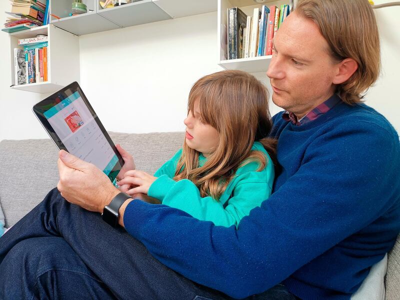 In this photo taken Oct. 21, 2018, Paddy Kelly and his daughter Ailish use Gohenry, one of a wave of digital banking apps for children, in London. A wave of digital pocket money apps that come with prepaid cards are new tools for financial education as money increasingly goes digital, in a shift thatâ€™s raising uncertainty about how cashless transactions affect youngstersâ€™ view of money. (AP Photo/Kelvin Chan)