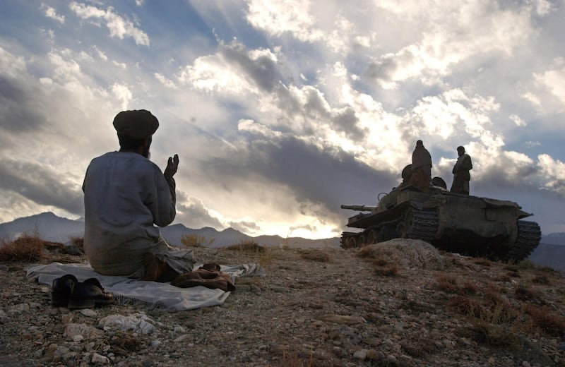 398395 02: An anti-Taliban soldier prays near a tank December 10, 2001 on the hills overlooking the Tora Bora area of Afghanistan. Anti-Taliban soldiers bombed and fought hand to hand with al Qaeda fighters in an attempt to oust the estimated 2,000 soldiers loyal to Osama bin Laden that are holed up in caves in the rugged countryside. (Photo by Chris Hondros/Getty Images)