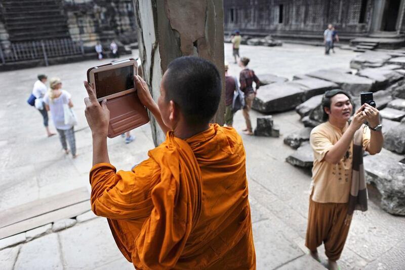 A Buddhist monk uses a tablet to take pictures as he visits the Angkor Wat temple, part of the Angkor architectural complex in north-western Cambodia. Cambodia’s Angkor Wat has been digitally mapped for the first time, allowing people to visit the famed temples from the comfort of their armchair using Google Street View. Christophe Archambault / AFP