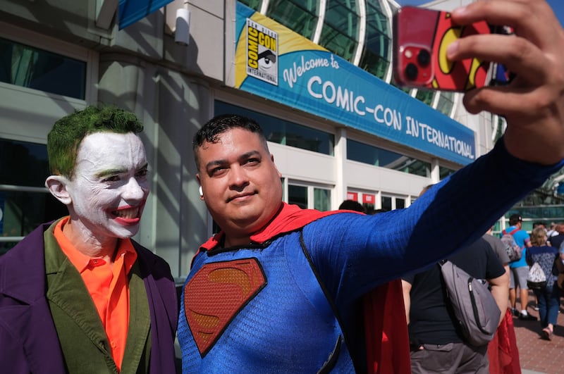 Fans cosplaly as the Joker, left, and Superman. EPA