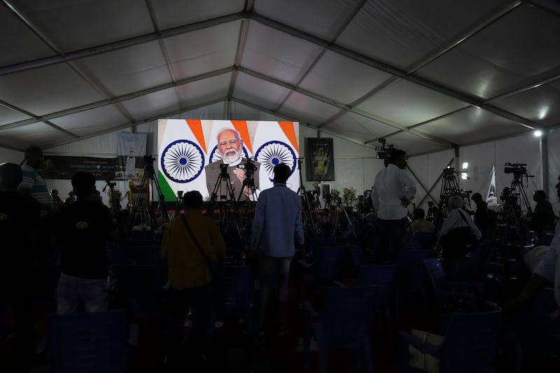 Indian Space Research Organisation staff and journalists watch Mr Modi speak after the successful landing. AP