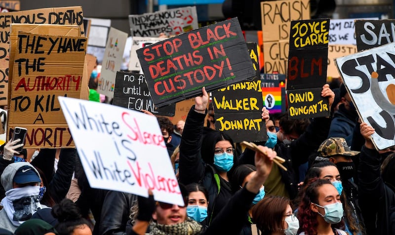 People hold placards at a Black Lives Matter protest to express solidarity with US protesters, in Melbourne on June 6, 2020. AFP