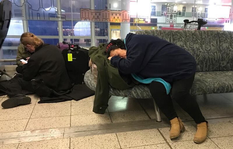 Passengers wait at Gatwick Airport after flights were cancelled due to the drone activity. AP Photo