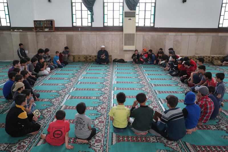 Syrian boys read the Quran at a mosque in Syria's northwestern city of Idlib. AFP