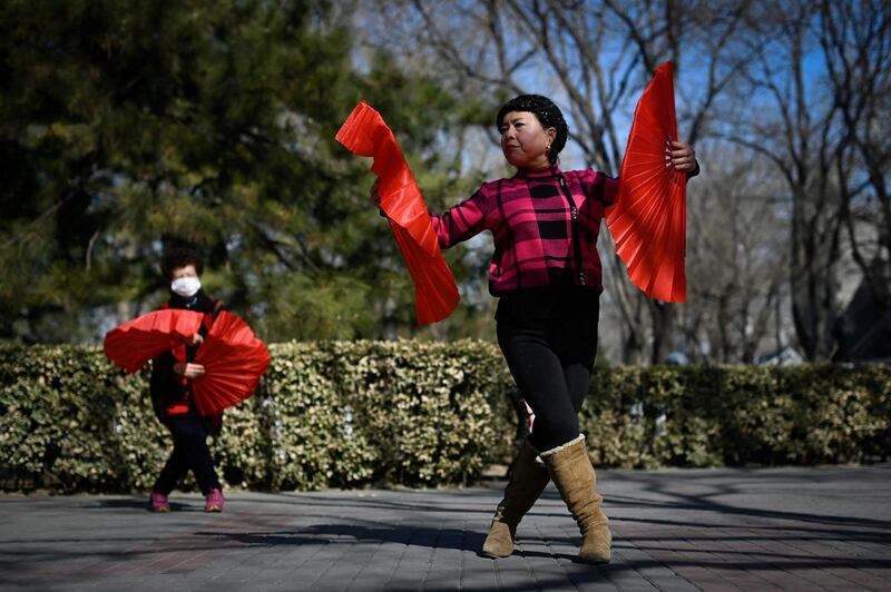 Two women dance along a road in the Chinese capital of Beijing. AFP