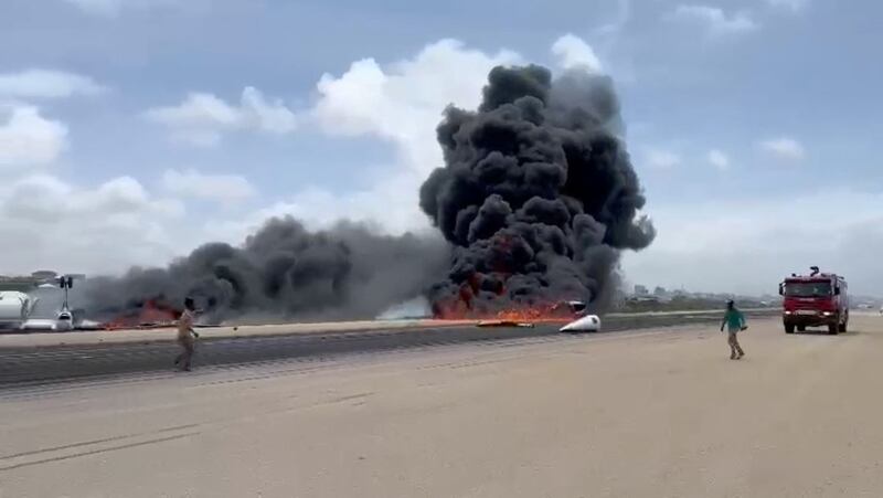 Smoke billows from a plane that flipped over after a crash landing in Mogadishu in this picture obtained from social media. Photo: Abdirahman Mohamed Arab via Reuters