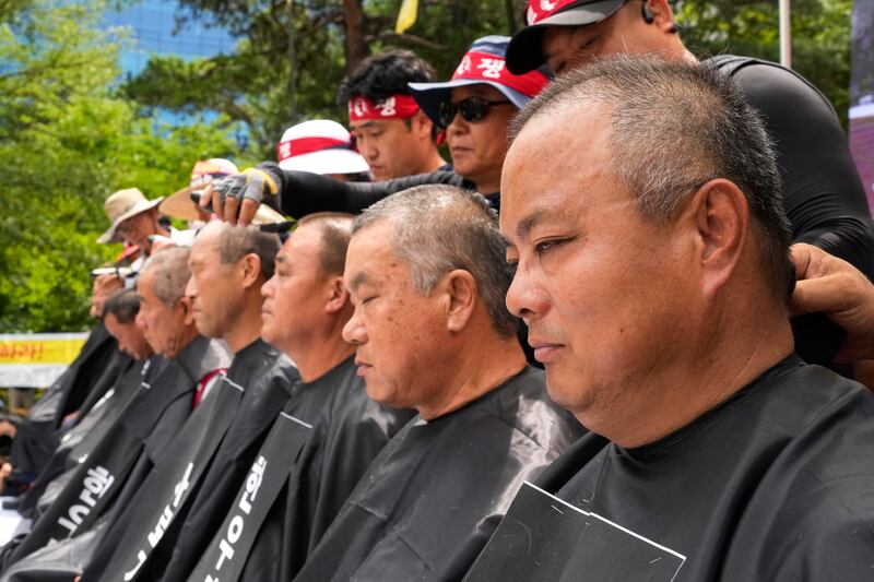 Korean cattle farmers, demanding a reduction in cattle feed price, have their heads shaved as they stage a rally near the National Assembly in Seoul, South Korea. AP