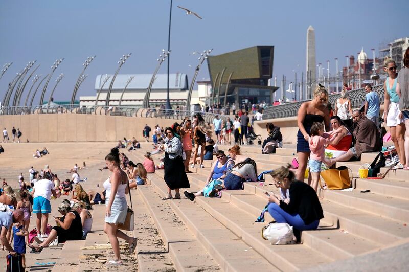 BLACKPOOL, UNITED KINGDOM - MAY 20: (EDITORS NOTE: This image was taken with a telephoto lens which compresses perspective) People head to the beach as England basks in sunshine on May 20, 2020 in Blackpool, United Kingdom. Parts of the country were expected to reach 29 degrees celsius, luring sunbathers and testing the capacity of parks and beaches to accommodate social distanced crowds. (Photo by Christopher Furlong/Getty Images)