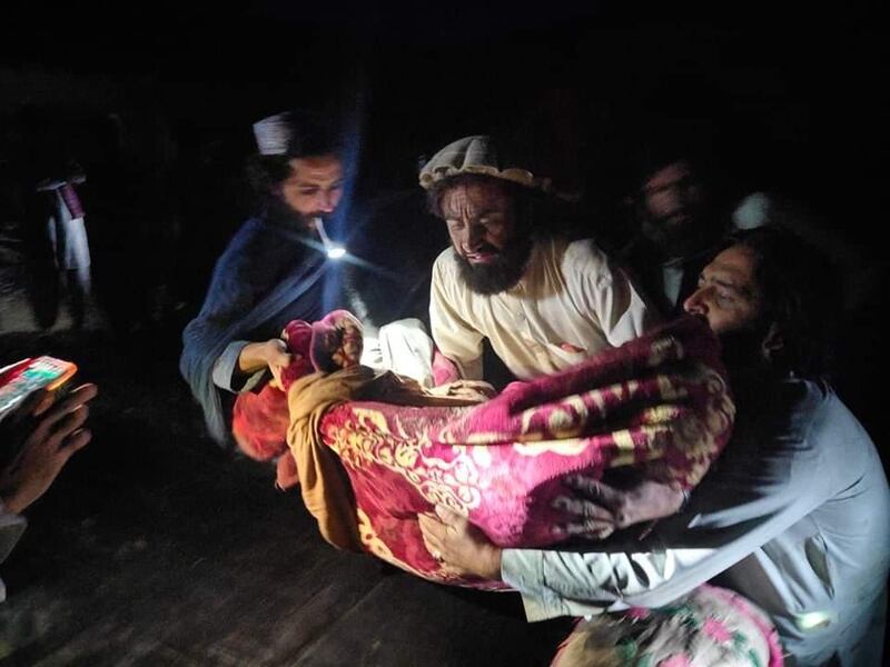 The body of a child is recovered following the quake, which was also felt in Pakistan and India.