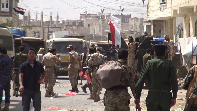 An image grab taken from AFP TV on December 2, 2017 shows Houthi rebel fighters walking down a street in the capital Sanaa. AFP