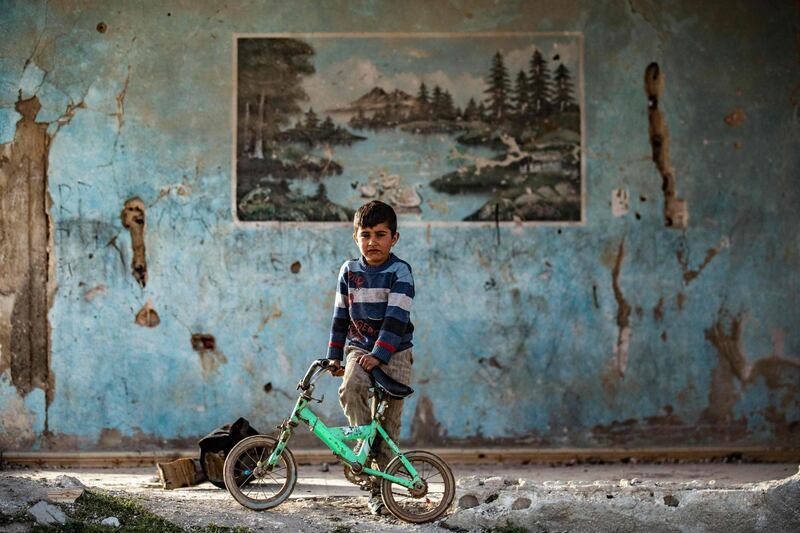 A boy stands next to a damaged house in the Syrian Kurdish town of Kobani, also known as Ain Al Arab, in Aleppo province. AFP