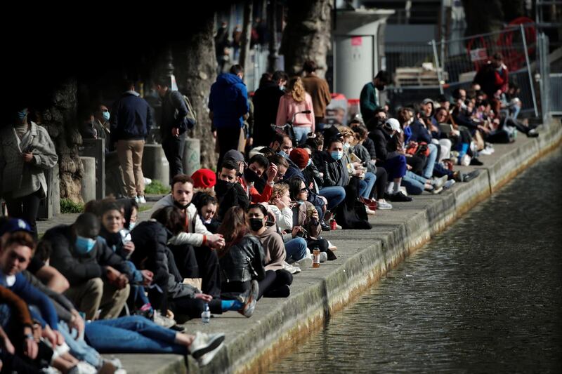 People enjoy a sunny spring day along the banks of the canal Saint-Martin in Paris, France. Reuters