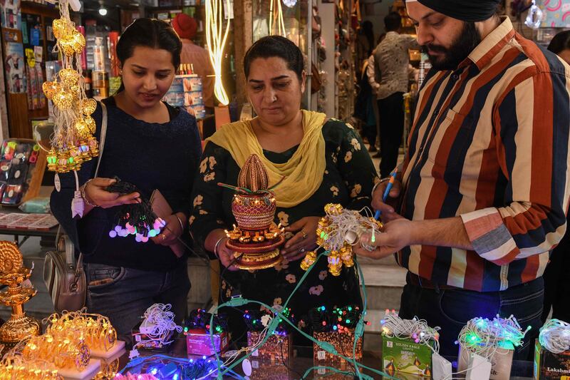 People buy decorative items at a market in Amritsar. AFP