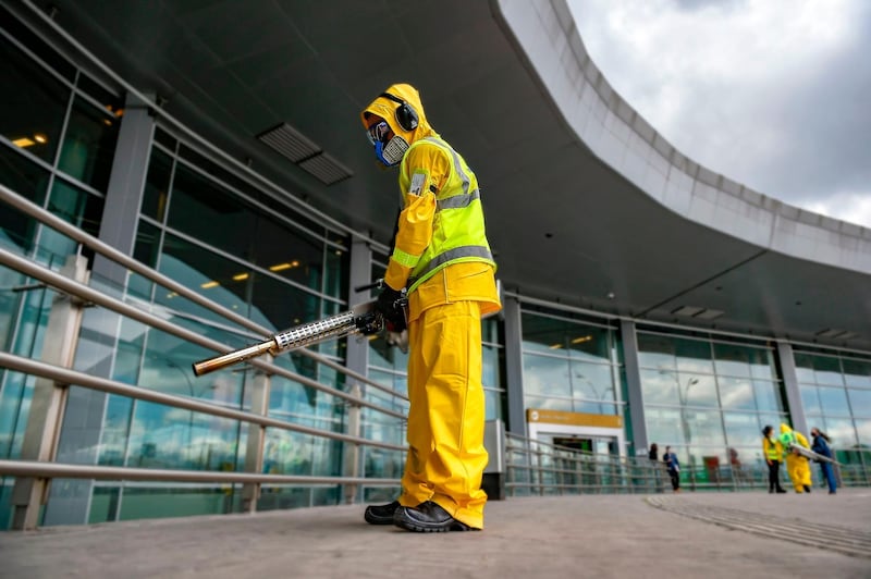 A worker disinfects an area outside El Dorado International Airport in Bogota. AFP