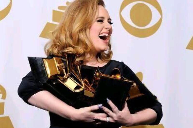 The British singer Adele holds up her Grammy Awards in the press room on Sunday night. She won six Grammys for Record of the Year, Album of the Year, Song of the Year, Best Pop Solo Performance, Best Pop Vocal Album and Best Short Form Music Video.