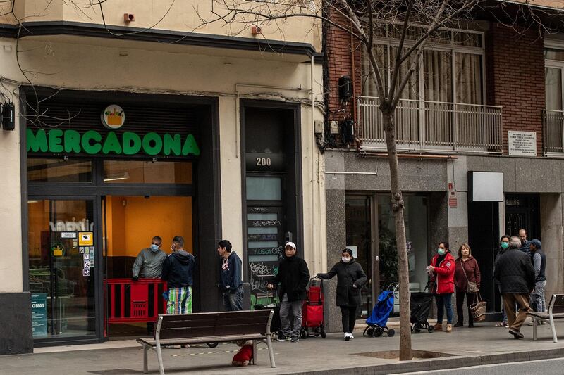 People keep their distance as they wait their turn in a queue to access a Mercadona supermarket in Barcelona, Spain. David Ramos / Getty