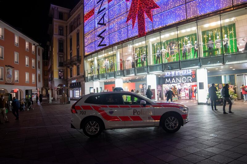 A police car in the area where a stabbing occurred in the department store, in Lugano, Switzerland, Tuesday, Nov. 24, 2020. Swiss authorities are investigating as a possible terror attack the stabbing of two women in an department store in the southern city of Lugano, and a suspect has been arrested. Officials said one of the victims sustained serious but not life-threatening injuries, while the other sustained minor injuries. (Ti-Press/Keystone via AP)