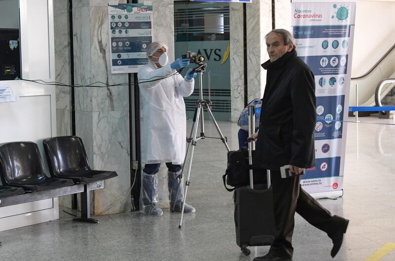 A health personnel monitors a thermal scanner as passengers arrive at Tunis-Carthage Airport in the Tunisian capital Tunis.  AFP
