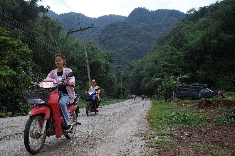 Motorists along the road from the Tham Luang cave, in which 12 boys from the "Wild Boars" football team and their coach were trapped last year, in the Mae Sai district of Chiang Rai province. AFP