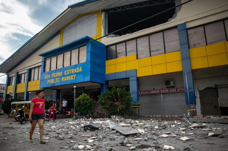 A resident walks past debris from a partially damaged building after a 6.4 magnitude earthquake hit the night before in the city of Digos, Davao del Sur province on the southern Philippine island of Mindanao on October 17, 2019. A child was killed in the strong 6.4-magnitude quake that hit the southern Philippines on October 16, a local mayor said, as houses collapsed, power was knocked out and a shopping mall burst into flames. / AFP / Manman Dejeto

