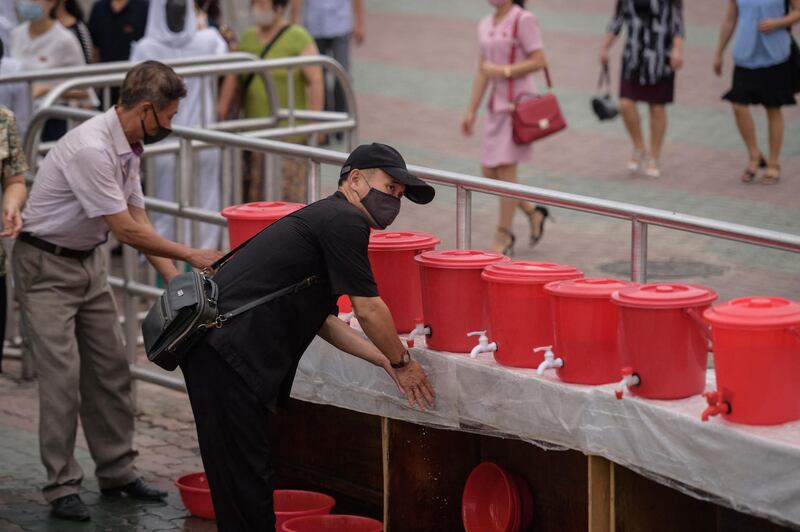 A man washes his hands as a preventative measure against the COVID-19 coronavirus at a hand-washing station outside a subway train station in Pyongyang on August 19, 2020. (Photo by KIM Won Jin / AFP)