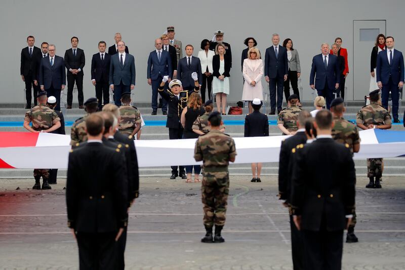 France's President Emmanuel Macron, background centre, sings the national anthem. AP