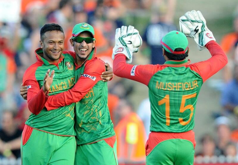 Bangladesh bowler Shakib Al Hasan, left, is congratulated by teammates Nasir Hossain and Mushfiqur Rahim, right, after taking the wicket. (AP Photo/Ross Setford)