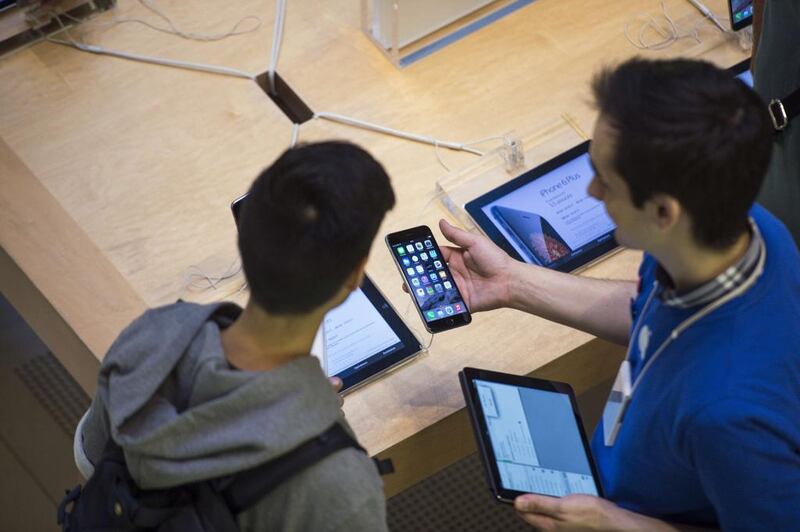 People check the latest iPhone, the iPhone 6, on the day of its launch in Paris. Fred Dufour / AFP Photo