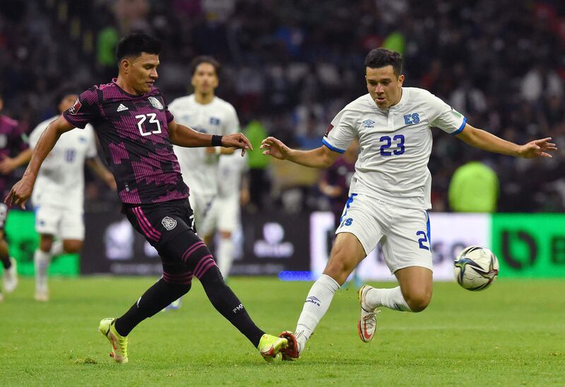 Mexico's Jesus Gallardo passes the ball under pressure from   Luis Vasquez of El Salvador. AFP