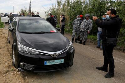 People gather near the car in which Lokman Slim, a prominent Lebanese Shi'ite critic of Iran-backed Hezbollah was found killed, in Addousieh