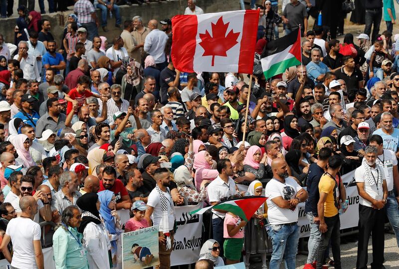 Hundreds of Palestinian refugees waving Palestinian and Canadian flags request asylum at a rally outside the the Canadian Embassy, in Beirut, Lebanon.  AP