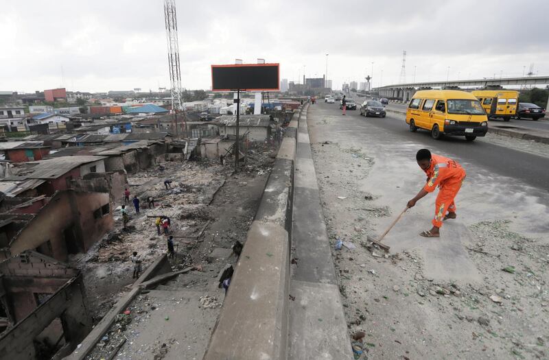 A worker cleans a street, as Nigeria's Lagos state eases a round-the-clock curfew imposed in response to protests against alleged police brutality. Reuters