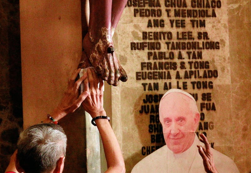 Filipino-Chinese pray next to a picture of Pope Francis inside a Catholic church in Manila , Philippines. EPA