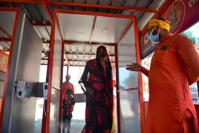 A Hindu devotee walks through a disinfection tunnel to enter the Bade Hanuman temple in Allahabad on June 8, 2020 as India reopened places of worship, hotels, restaurants and shopping malls after more than two months of lockdown to contain the spread of the novel coronavirus . AFP