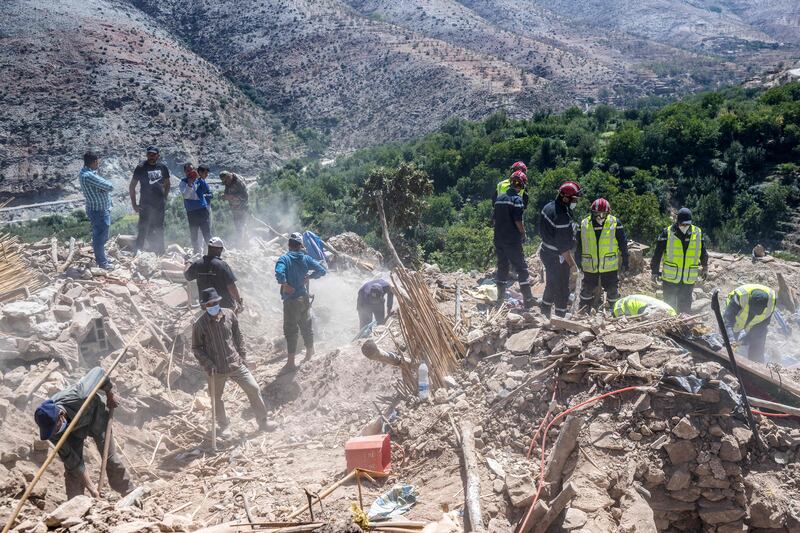 Rescuers and villagers sift through the rubble of a destroyed building in a village near Amizmiz. AFP