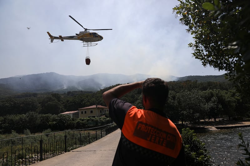A helicopter joins the effort to contain a wildfire at Garganta de los Infiernos nature reserve, in Jerte, central Spain. Reuters