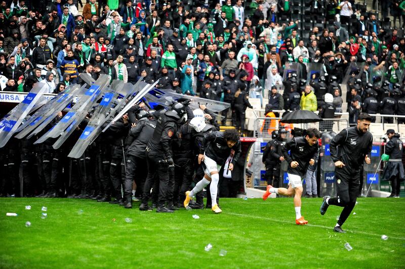 Riot police protect players of the Kurdish team Amedspor from objects thrown on to the pitch in a match against Bursaspor in Bursa, Turkey. AFP