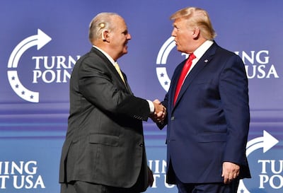(FILES) In this file photo taken on December 21, 2019, Rush Limbaugh shakes hands with US President Donald Trump during the Turning Point USA Student Action Summit at the Palm Beach County Convention Center in West Palm Beach, Florida. Limbaugh, the US conservative radio host who spent more than four decades on the air, has died at aged 70 after a battle with cancer, his family said February 17, 2021. / AFP / Nicholas Kamm
