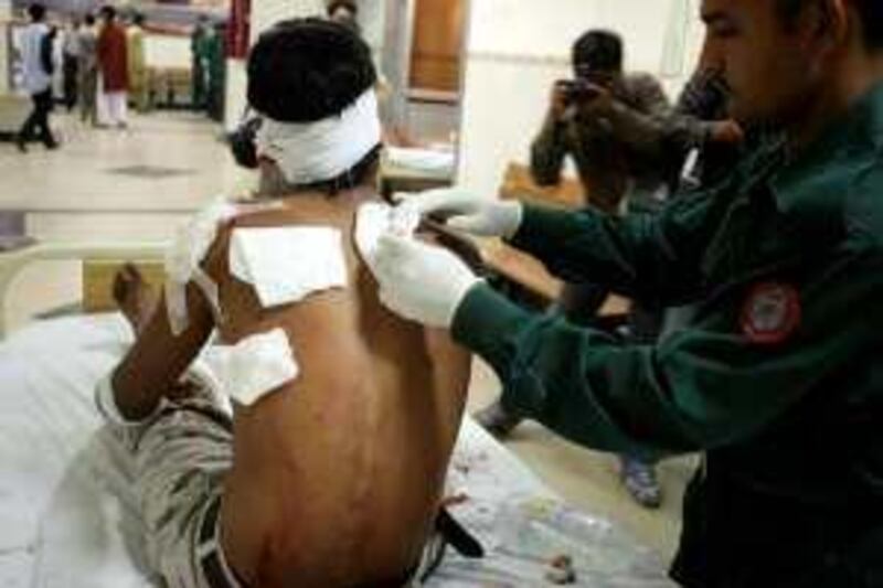 A Pakistani medical volunteer applies gauze to a blast victim's back at a hospital following a car bomb attack on a law enforcement building in Lahore on March 8, 2010. A car bomb devastated Pakistani offices used to interrogate suspected militants on March 8, killing 11 people in the latest attack to strike the country's teaming cultural capital of Lahore. More than 60 were wounded with people trapped under the rubble of collapsed buildings after a car packed with up to 600 kilograms (1,300 pounds) of explosives struck an investigations unit in Pakistan's second largest city. AFP PHOTO/ ARIF ALI *** Local Caption ***  035075-01-08.jpg *** Local Caption ***  035075-01-08.jpg