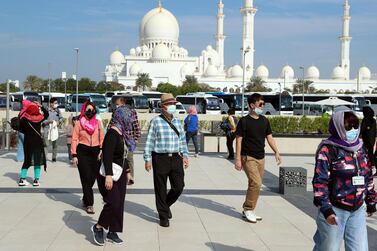 Visitors to Sheikh Zayed Grand Mosque in Abu Dhabi wear face masks in January. Chris Whiteoak / The National