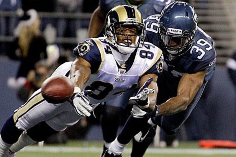 Seattle Seahawks tight end Zach Miller (86) is flipped over while being tackled by St. Louis Rams defensive tackle Fred Robbins, left, during the fourth quarter.