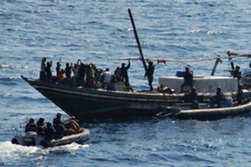 Indian marine commandos board a suspected pirate ship as its crew, left, surrender in the Gulf of Aden.