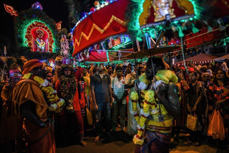 Hindu devotees carrying a "kavadi" (wooden frame) as they make their way towards the Batu Caves temple to make offerings during the Thaipusam festival in Batu Caves on the outskirts of Kuala Lumpur.  AFP