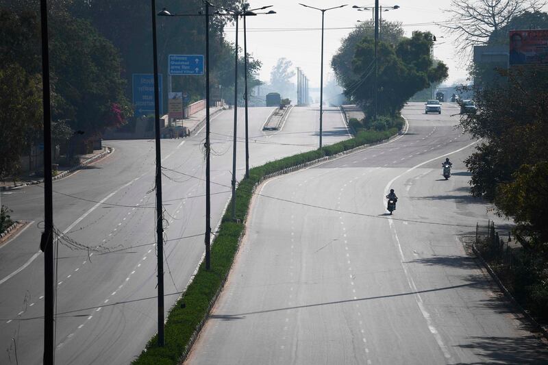 Vehicles move through a deserted road in Delhi.  AFP