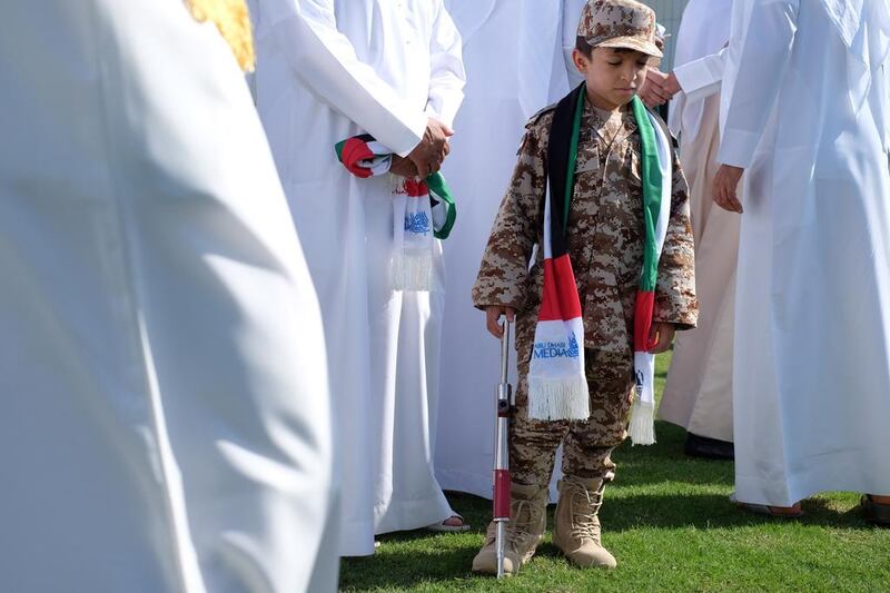 Khalid Alteneji observes a moment of silence with his family on Commemoration Day at Abu Dhabi Media in the capital on Wednesday. Delores Johnson / The National